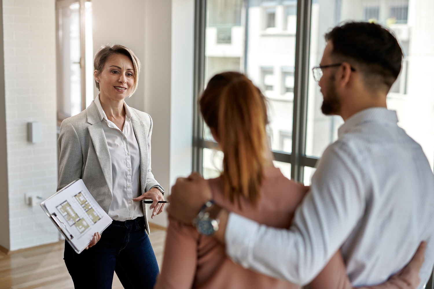Real estate agent talking to a couple interested in buying new h